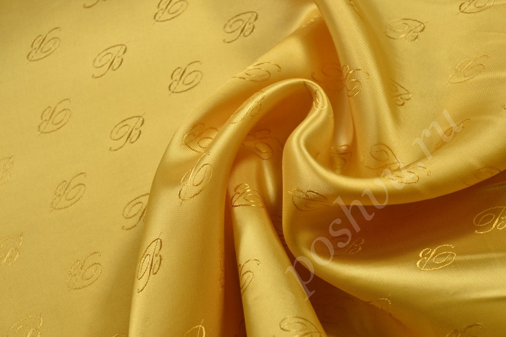 Ткань подкладочная желтого оттенка с буквами