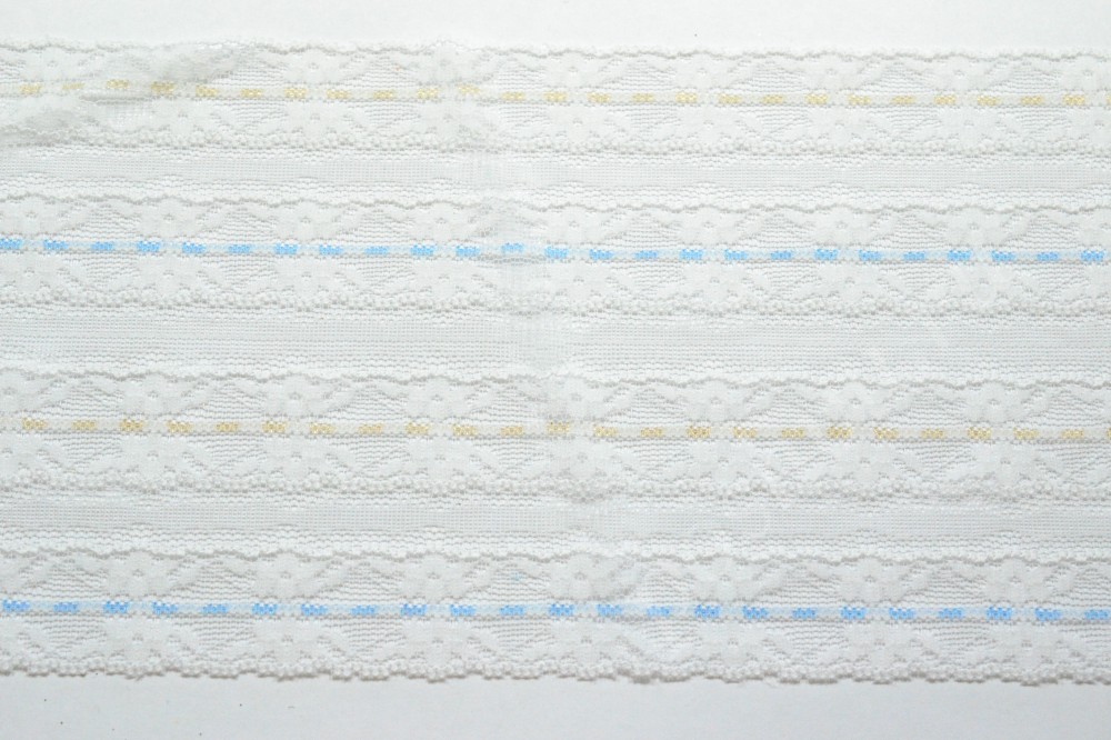 Ткань кружево белого цвета с голубыми и желтыми полосками